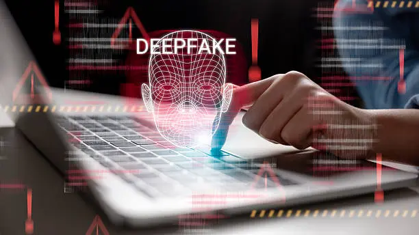 Deepfake detection concept showing a digital face scan on a laptop screen.